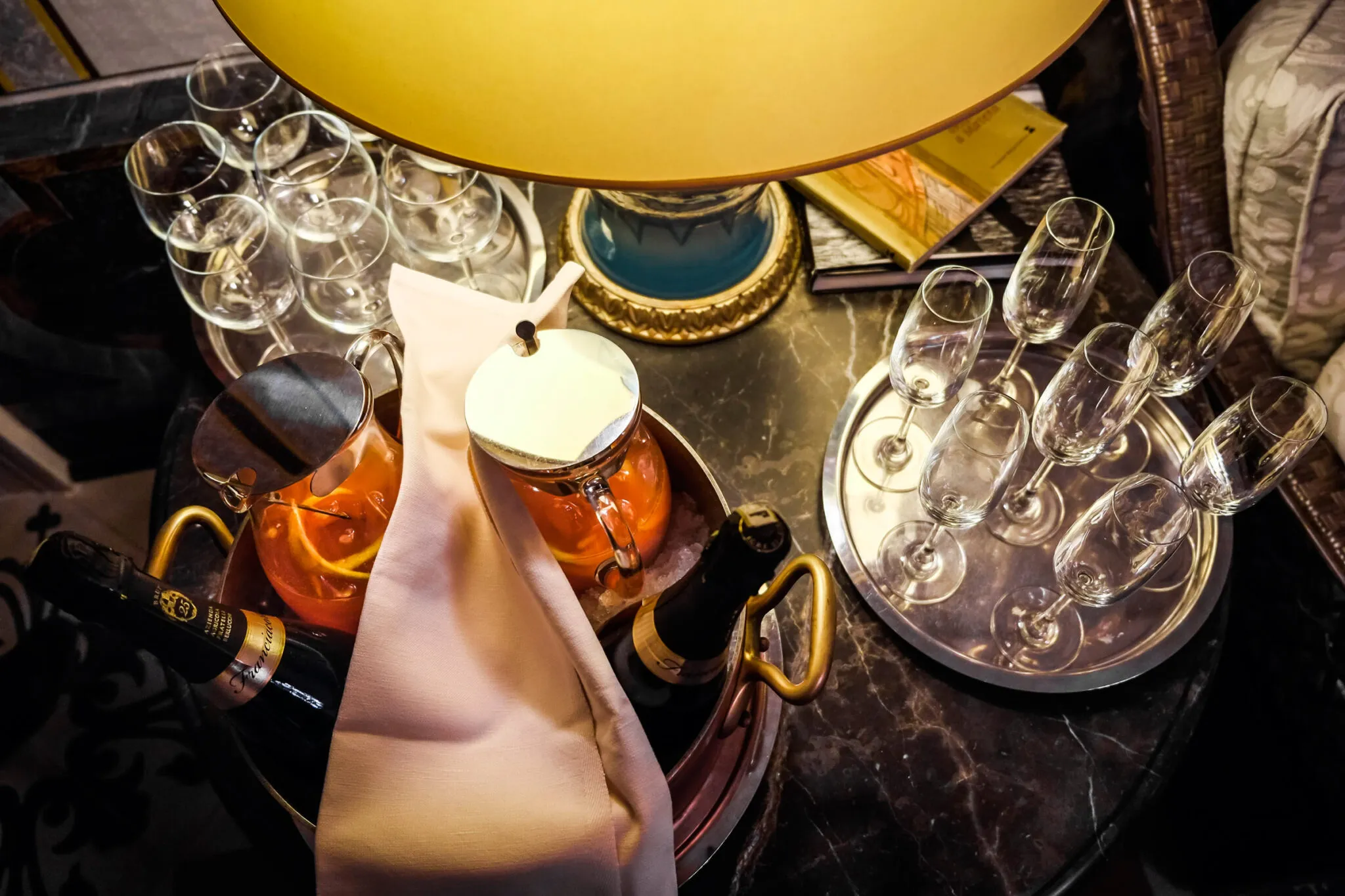 A table set with an ice bucket of sparkling wine and a tray of champagne flutes