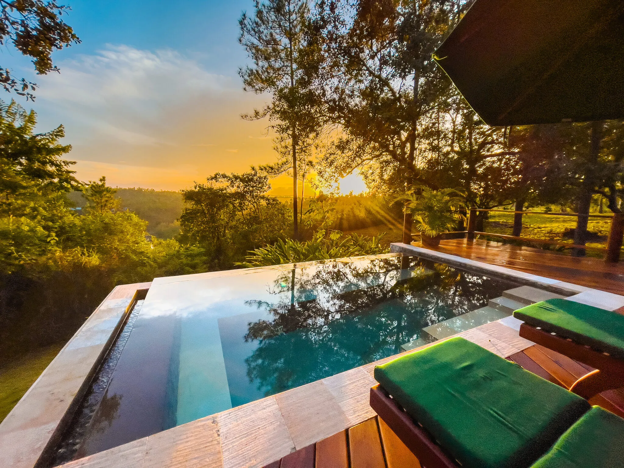 Swimming pool and lounge chairs at sunset