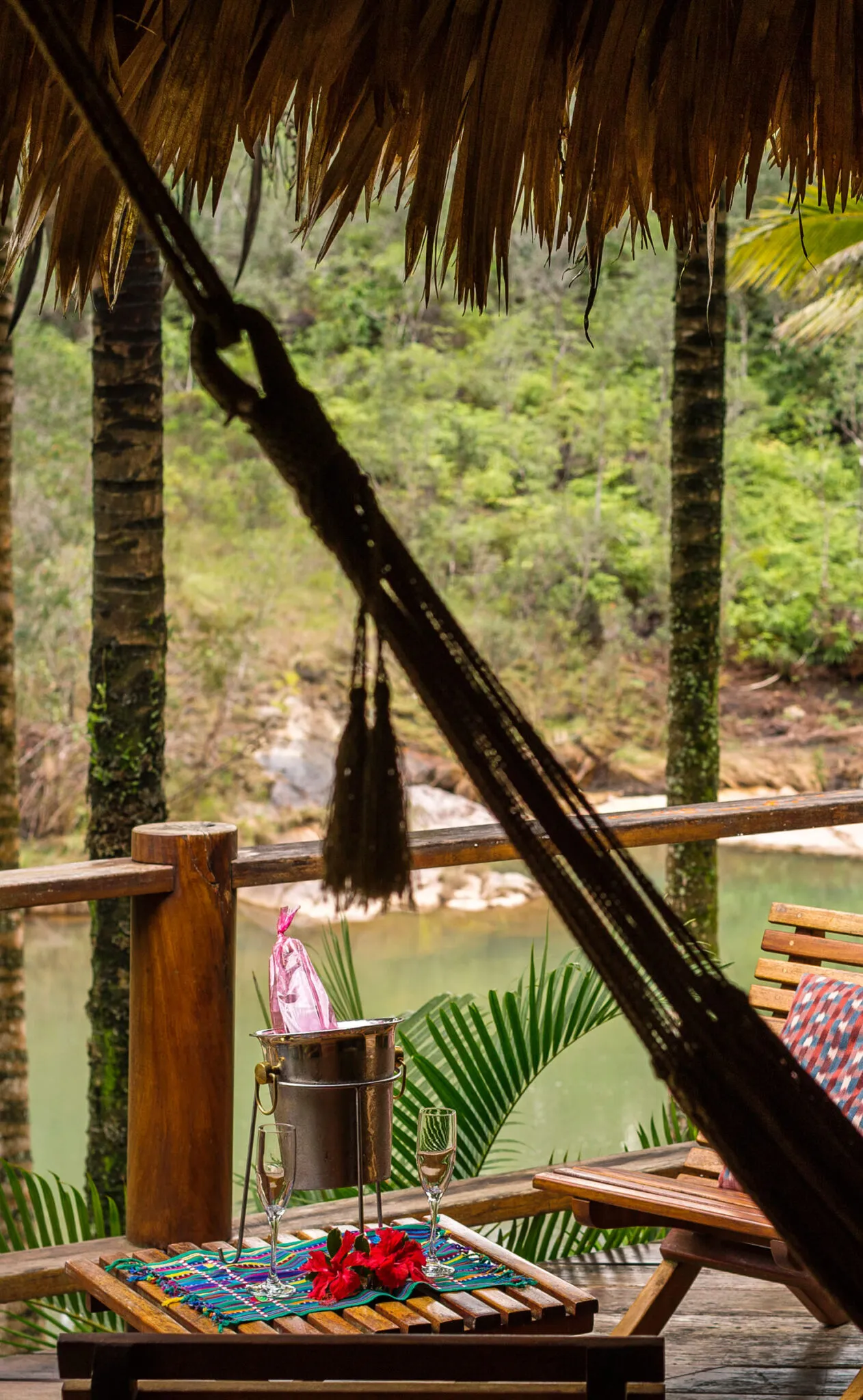 A hammock on a porch overlooking the water