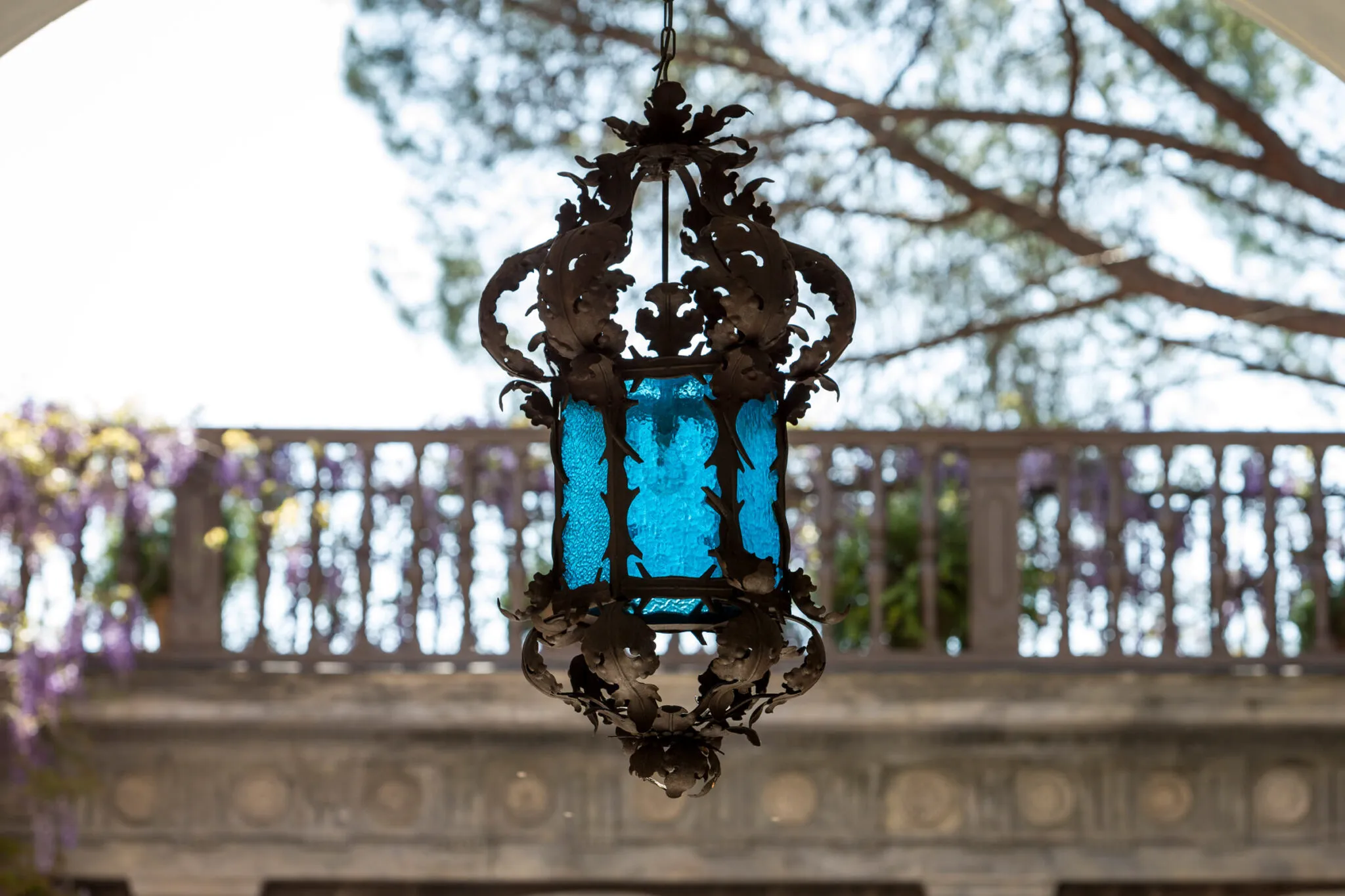 A blue glass and metal lantern hangs outside