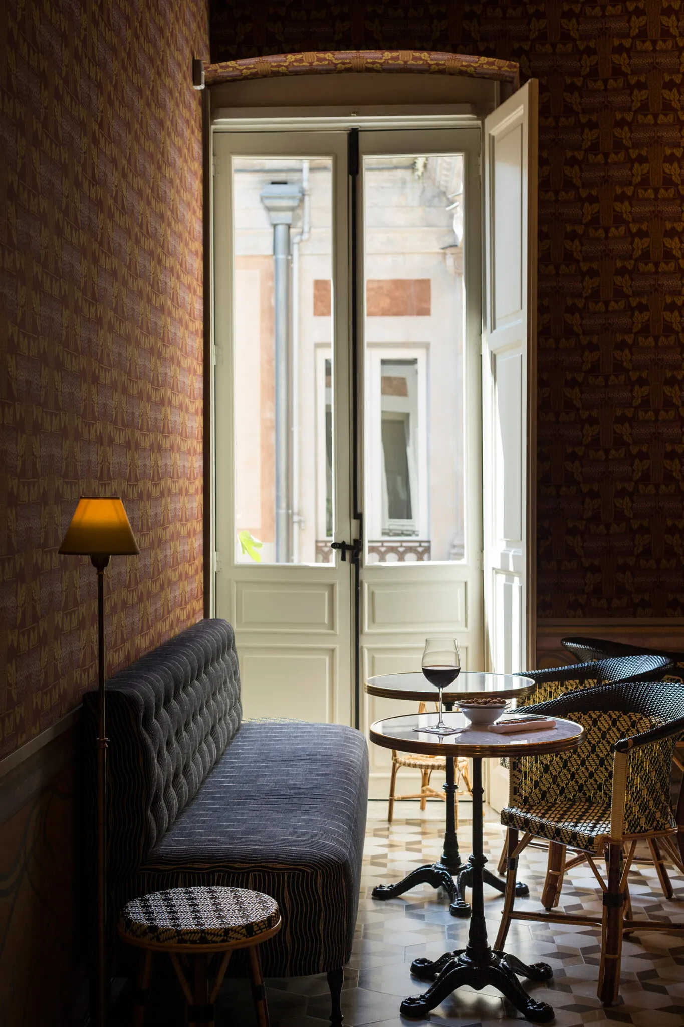 Cushioned bench seat and wicker chairs at a table