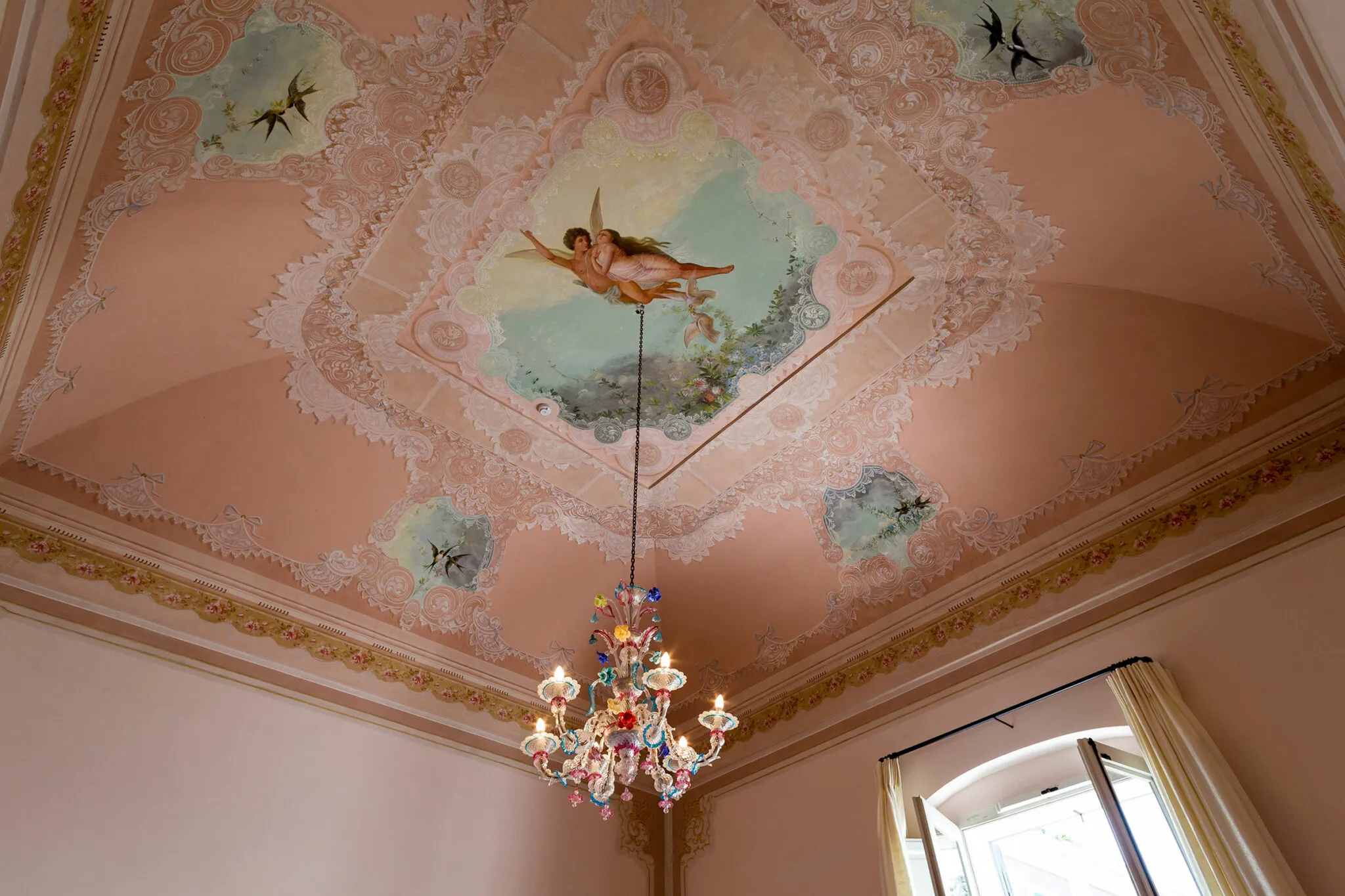 Pink ceiling with paintings of angels and birds