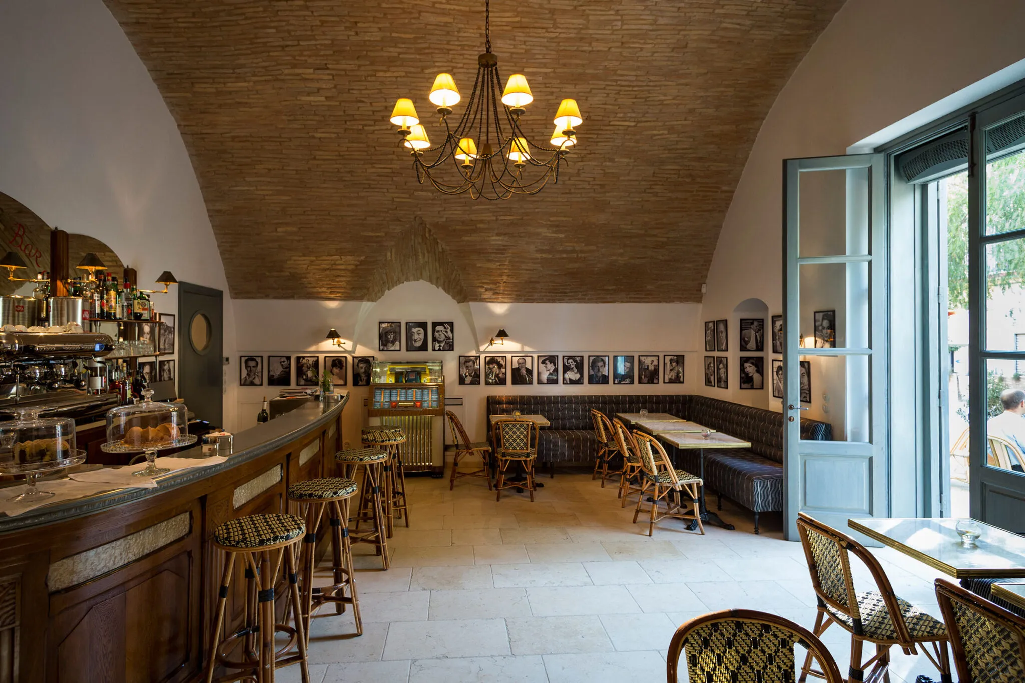 Cinecitta bar interior with bar and tables under an arched ceiling