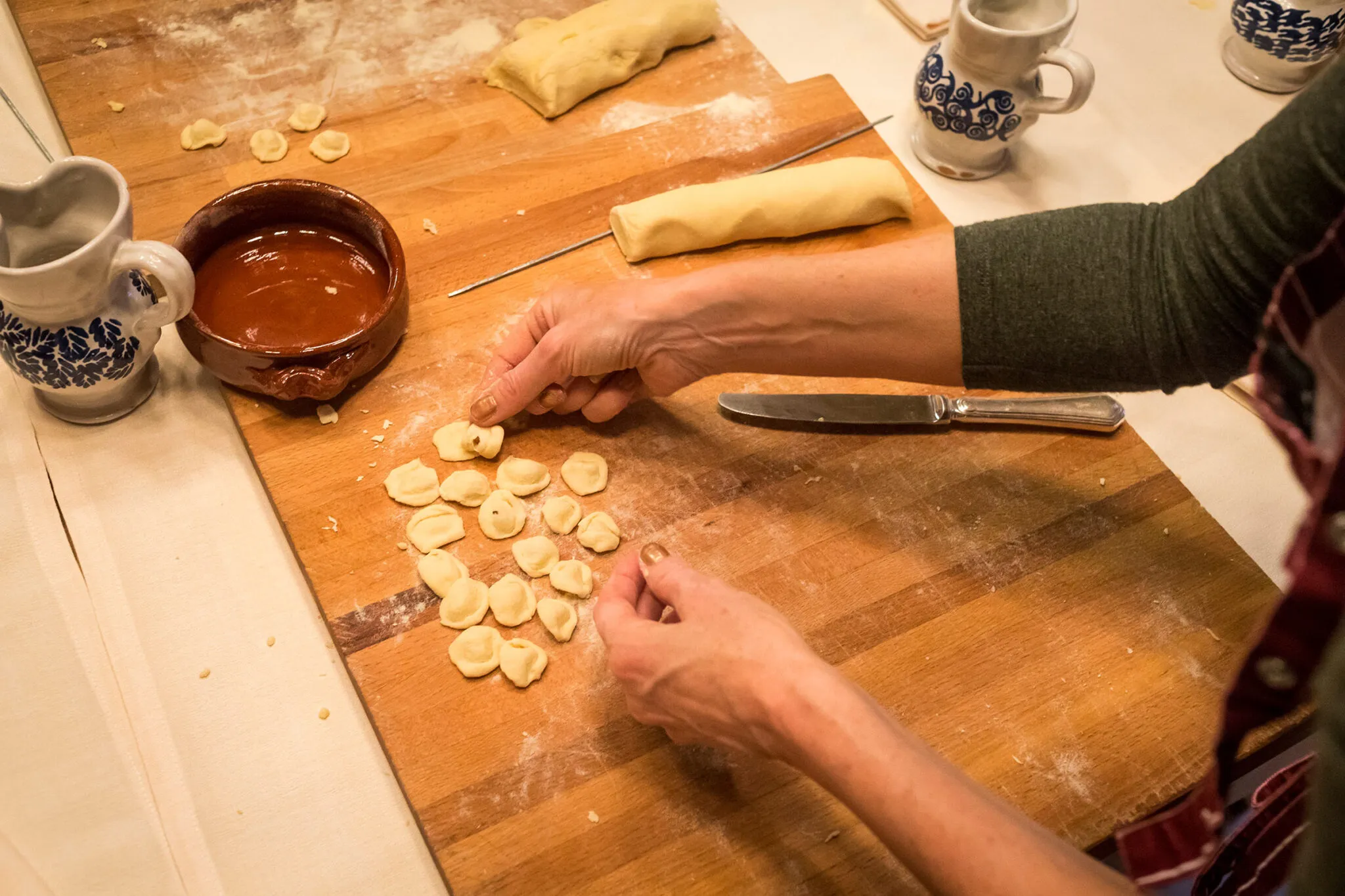 A close up of a woman's hands making pasta