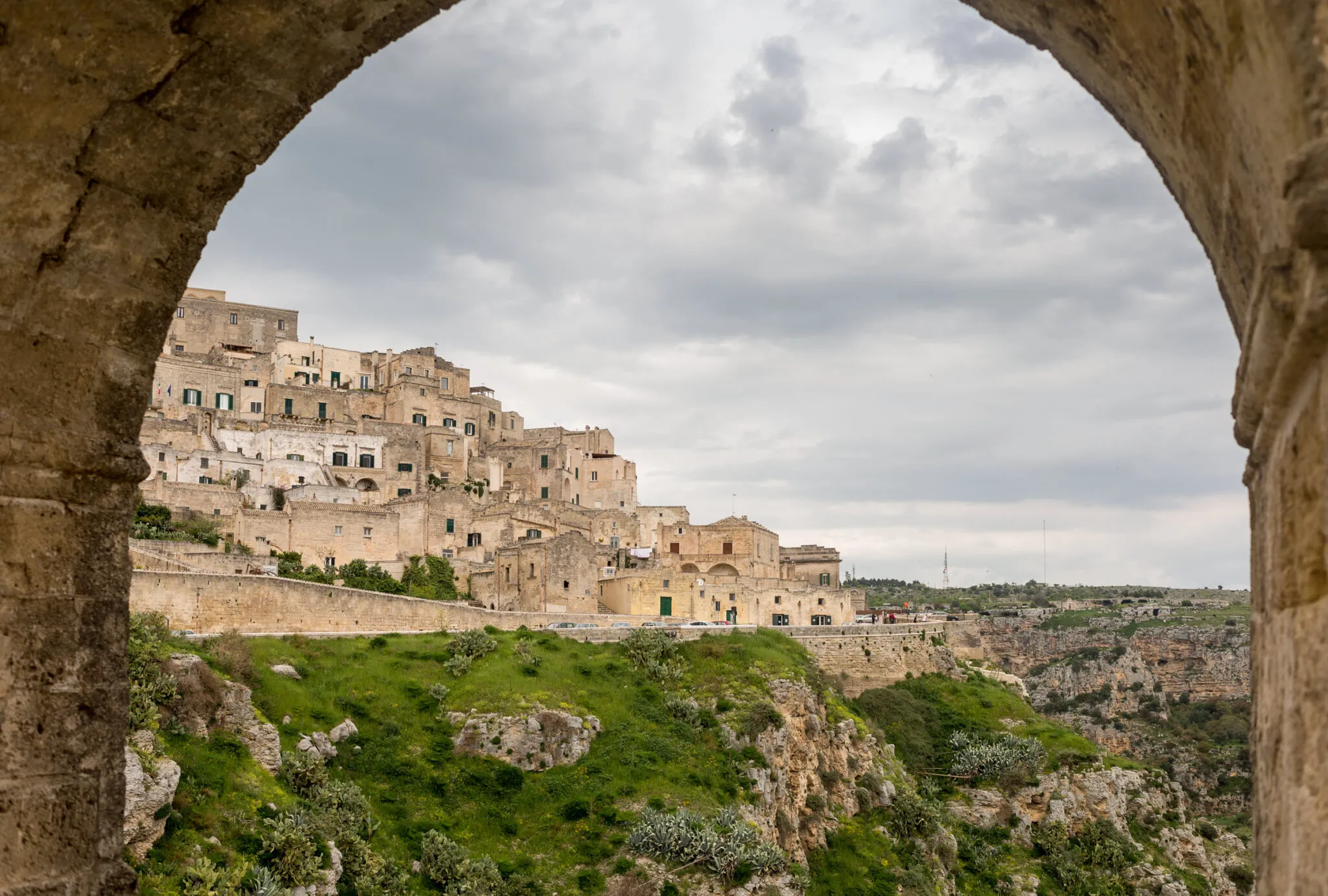 View of Matera on a hillside from under a stone archway