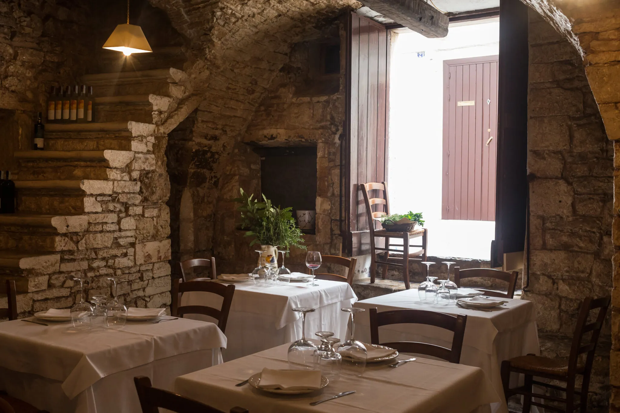 tables with white table cloths in an osteria