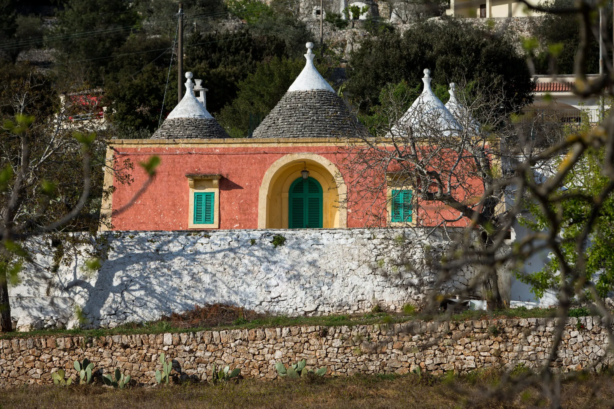 Red home with archways and multiple cones on the roof