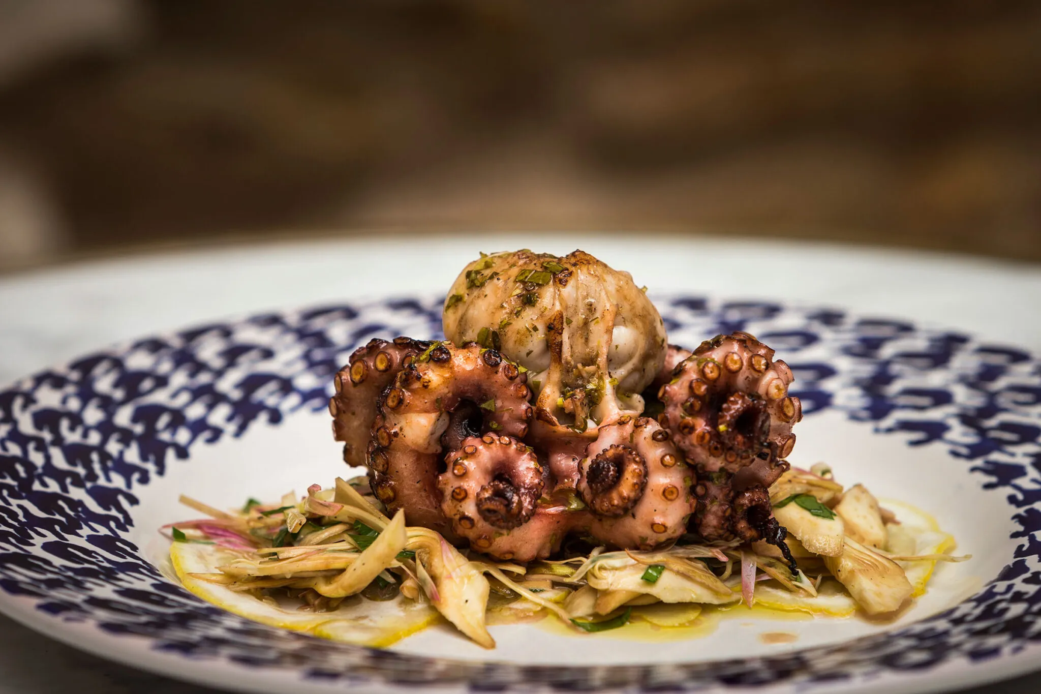 Whole cooked octopus on a bed of vegetables