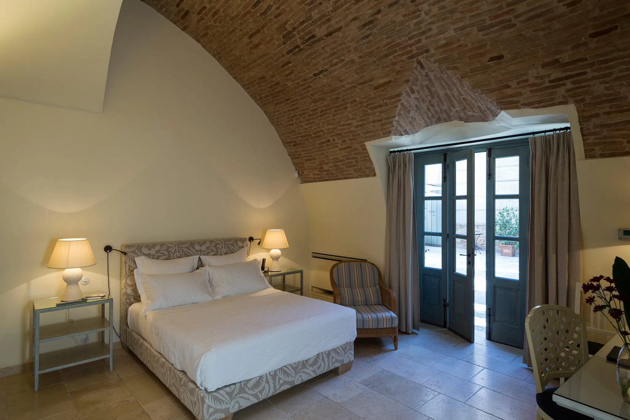 Double bed under arched brick ceiling