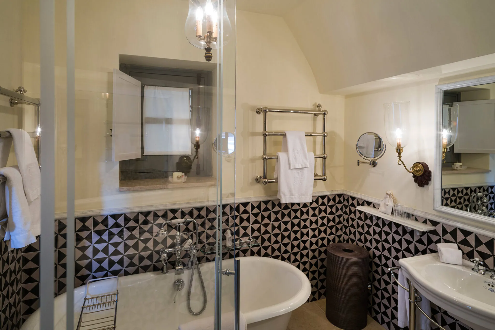 Clawfoot tub in bathroom with geometric tile