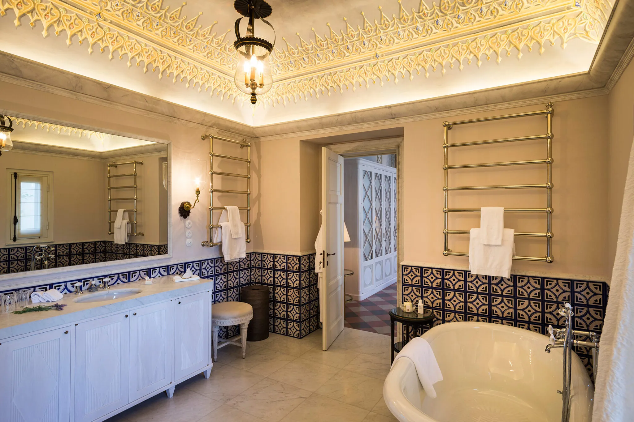 Bathroom with clawfoot tub under an ornate ceiling