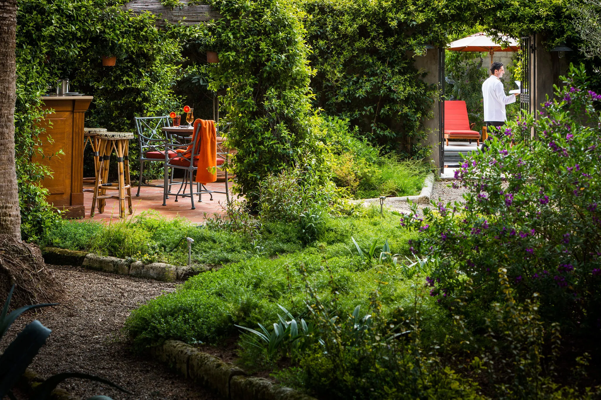 Dining table and lounge chairs in the pool bar garden