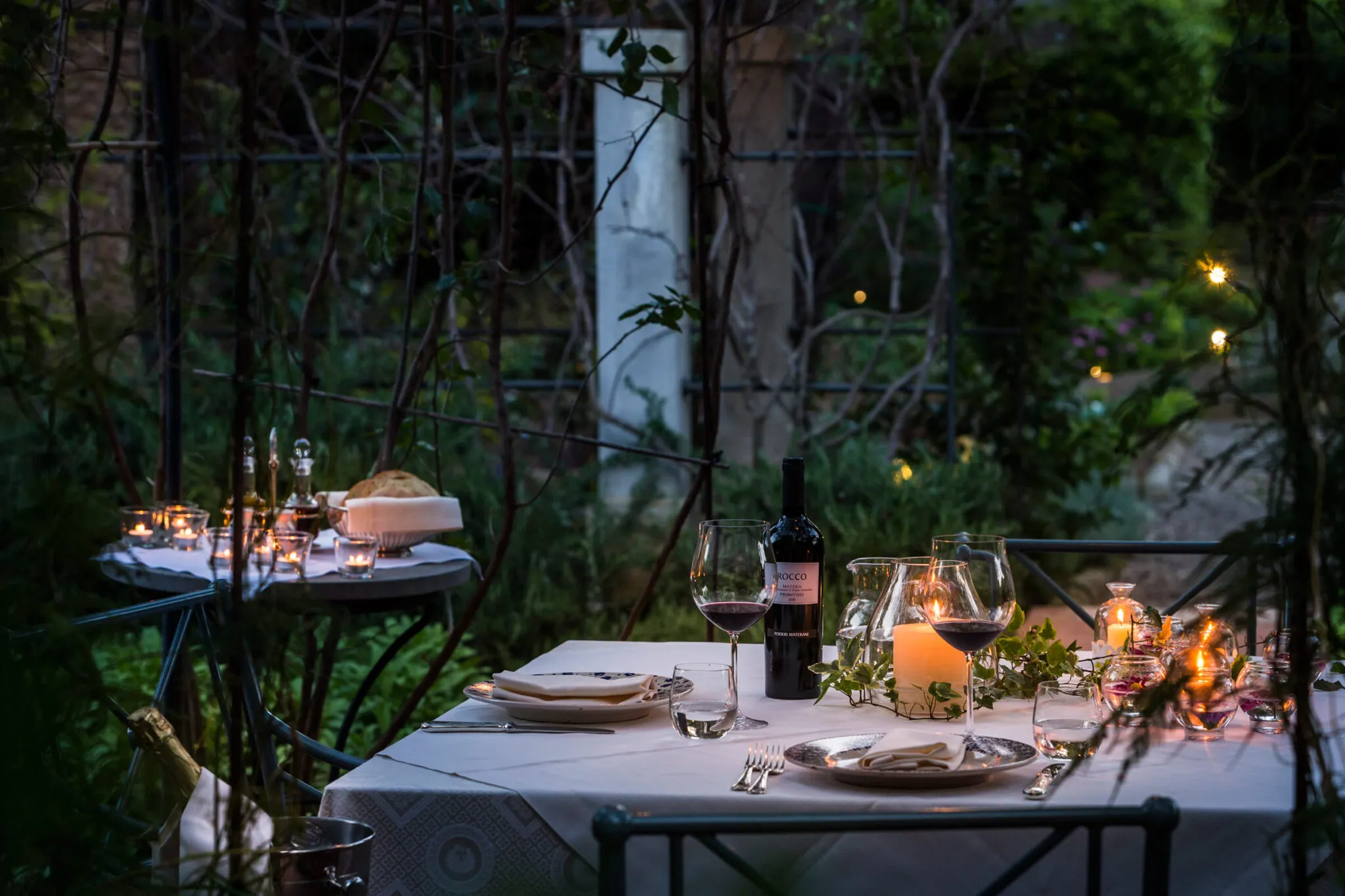 A dining table set in the garden at dusk