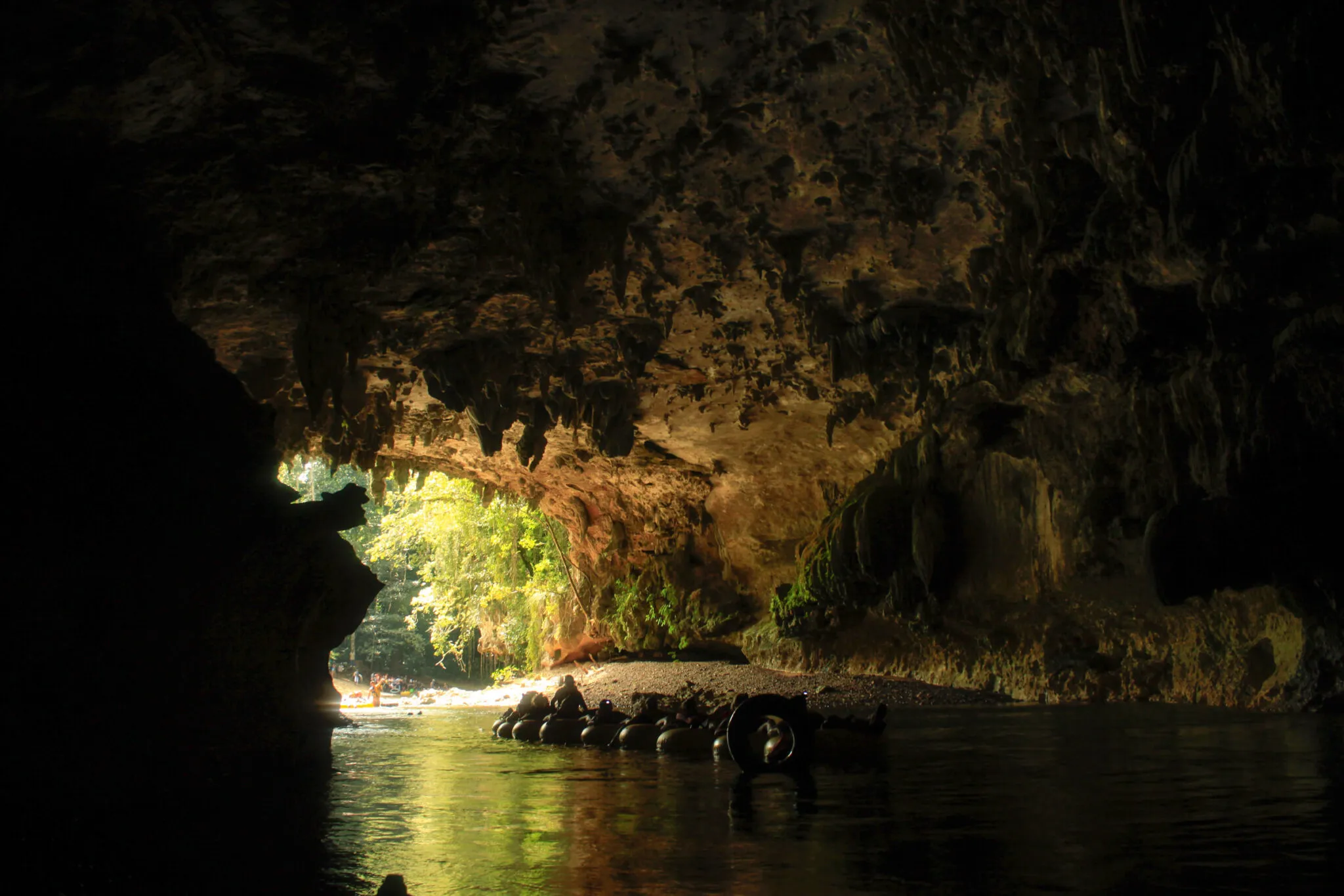 People inner tubing in a cave