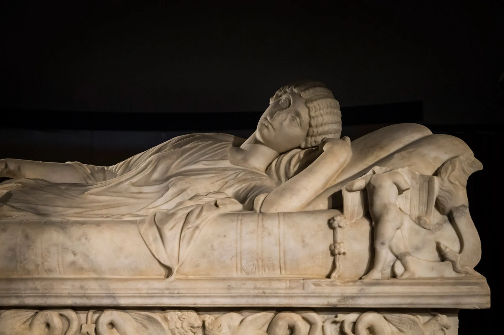 Detail of a woman carved in stone on a sarcophagus