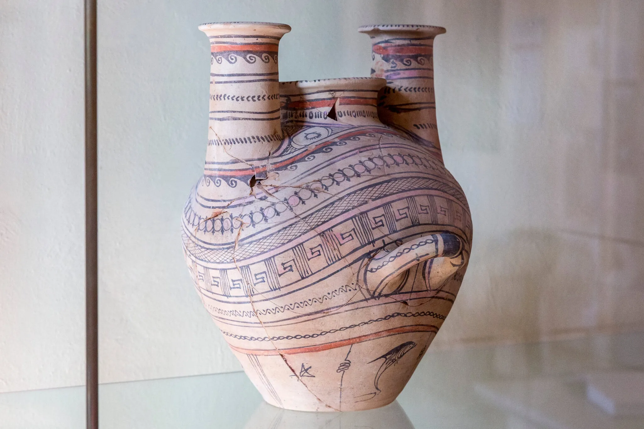 A clay pot with handle decorated with blue patterns