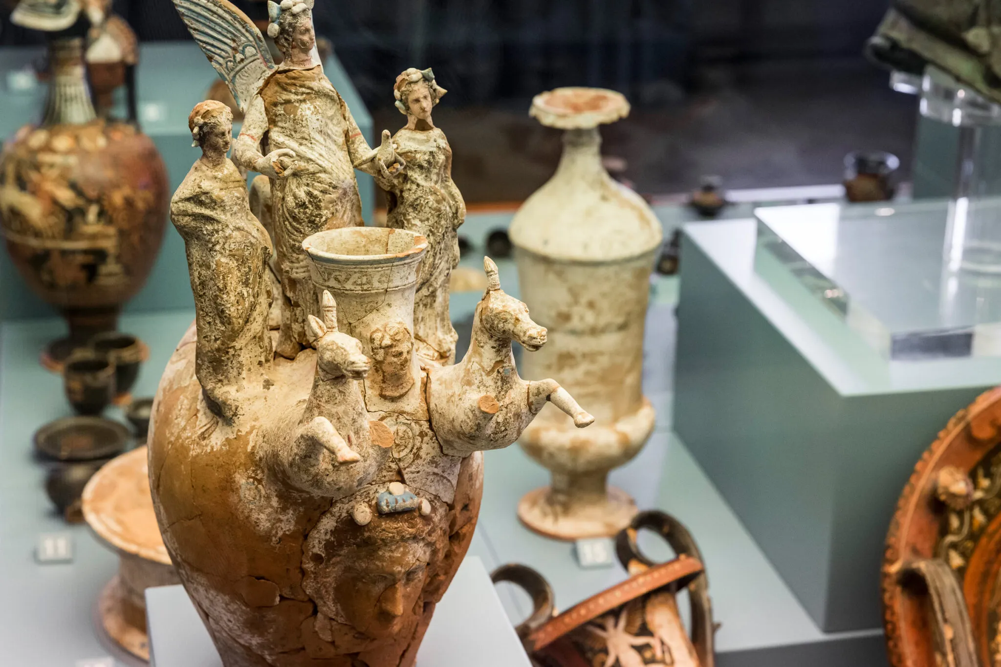 clay pottery decorated with human and animal figures