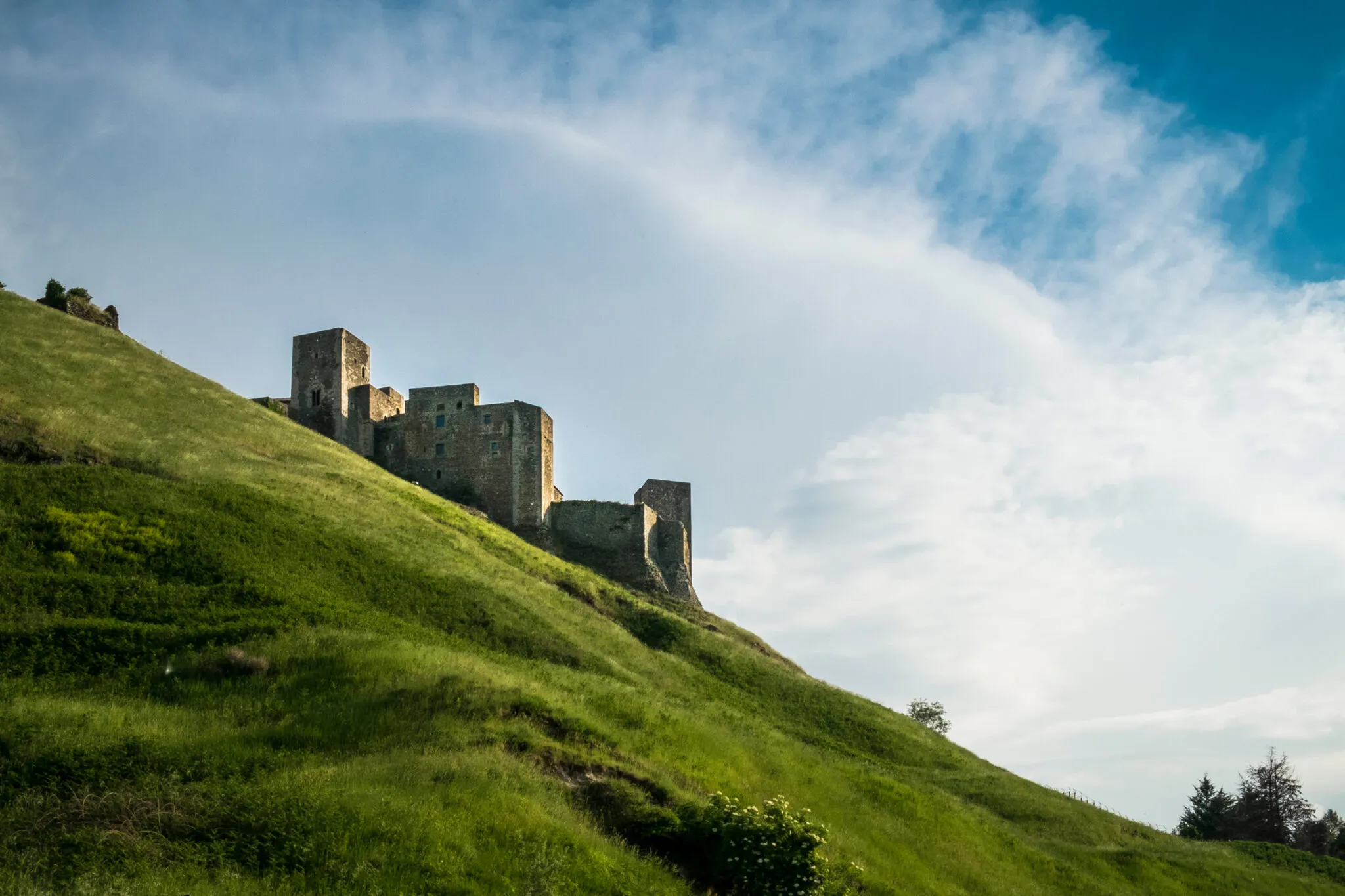 A stone building on a green hillside