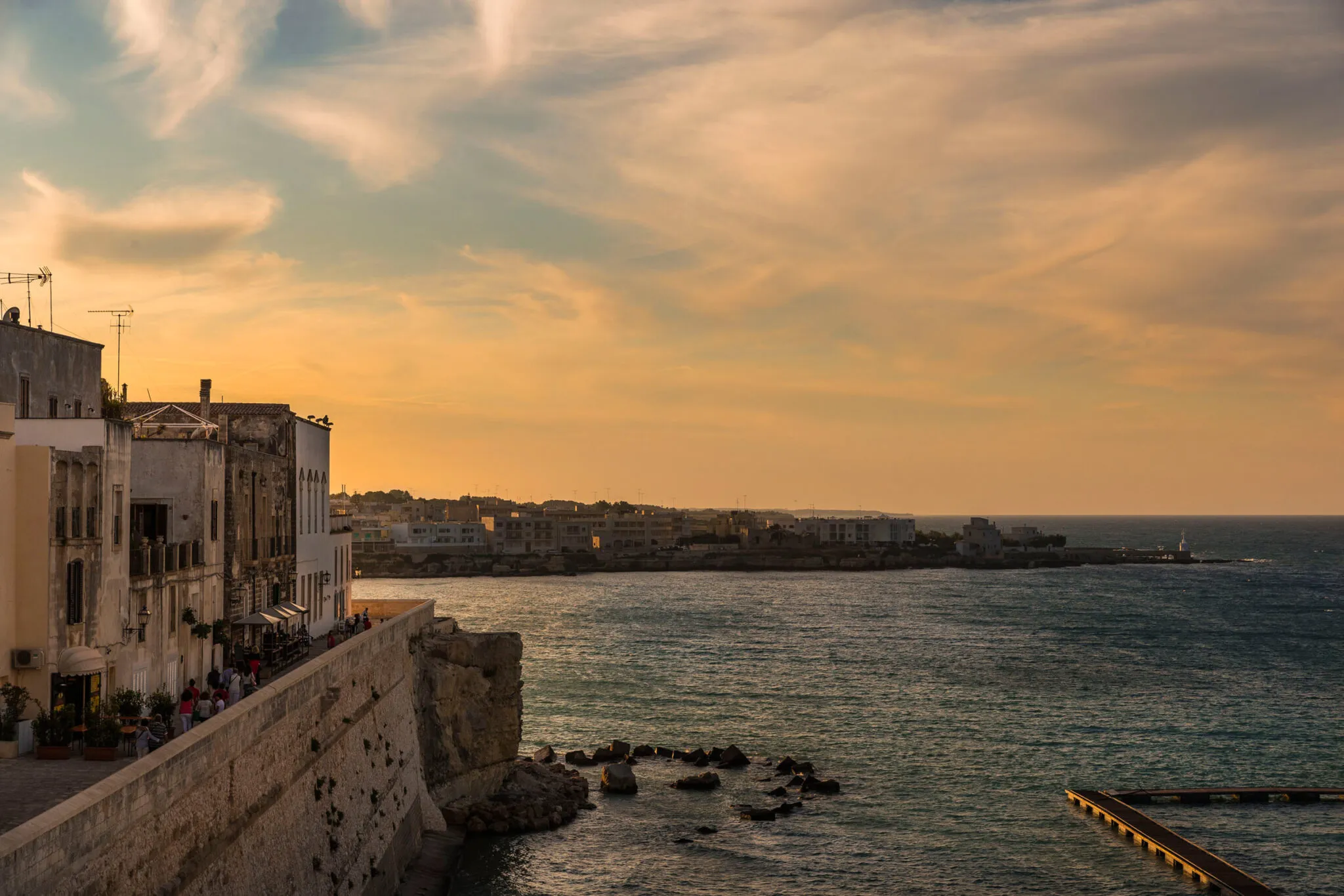 View of buildings on the shoreline and sea at sunset