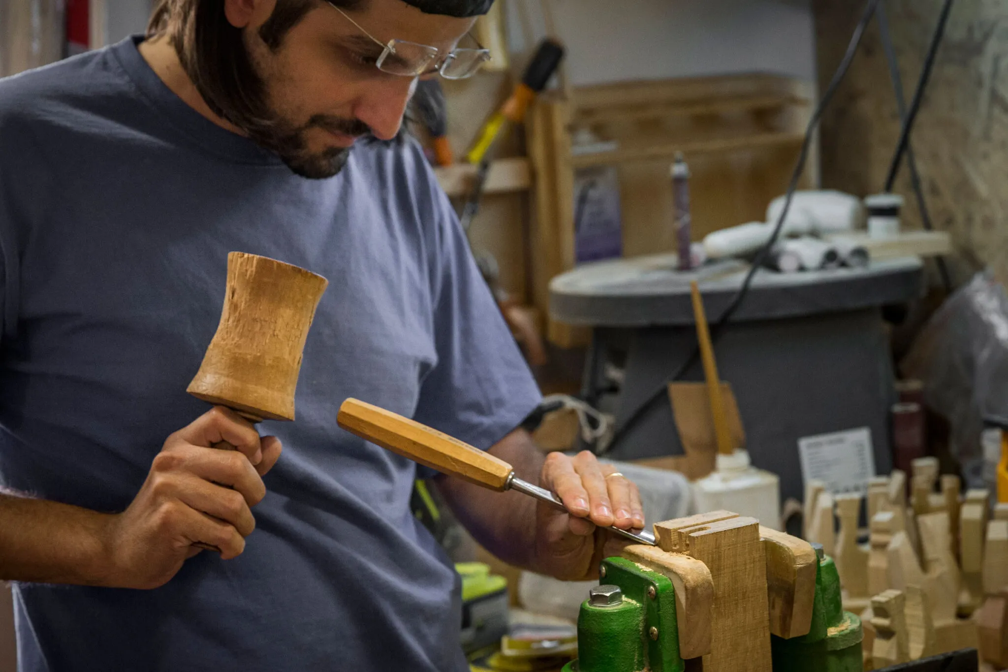 An artisan uses tools to carve wood