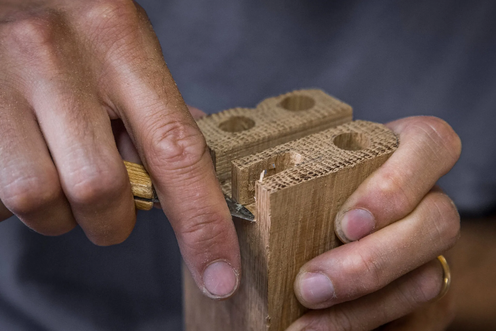 close up of an artisan's hands carving wood