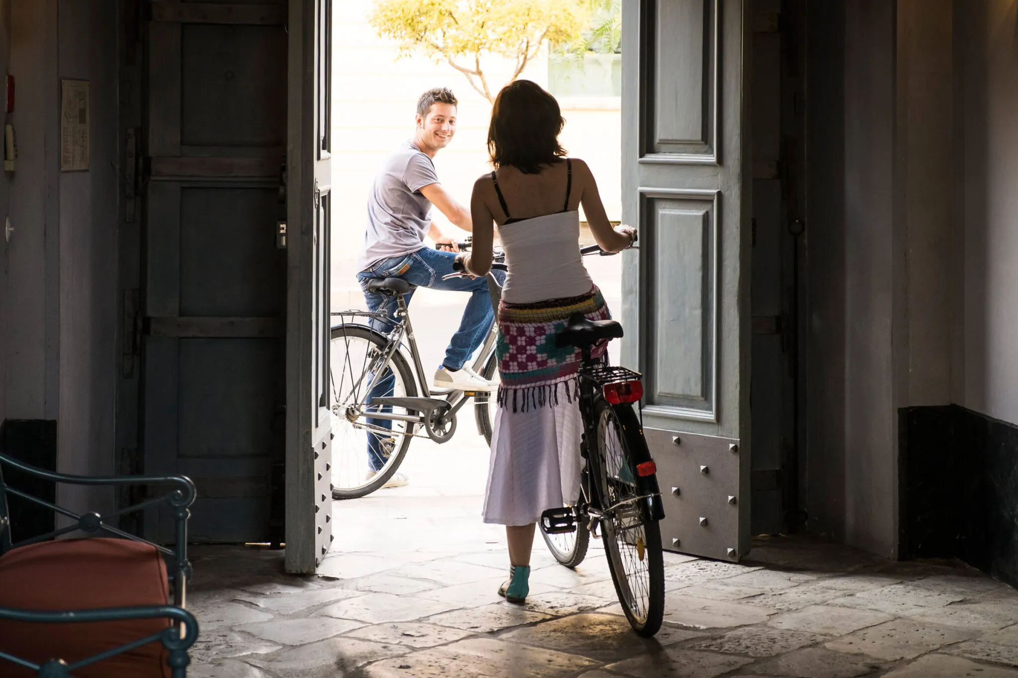 A woman on a bicycle greets a man on a bicycle