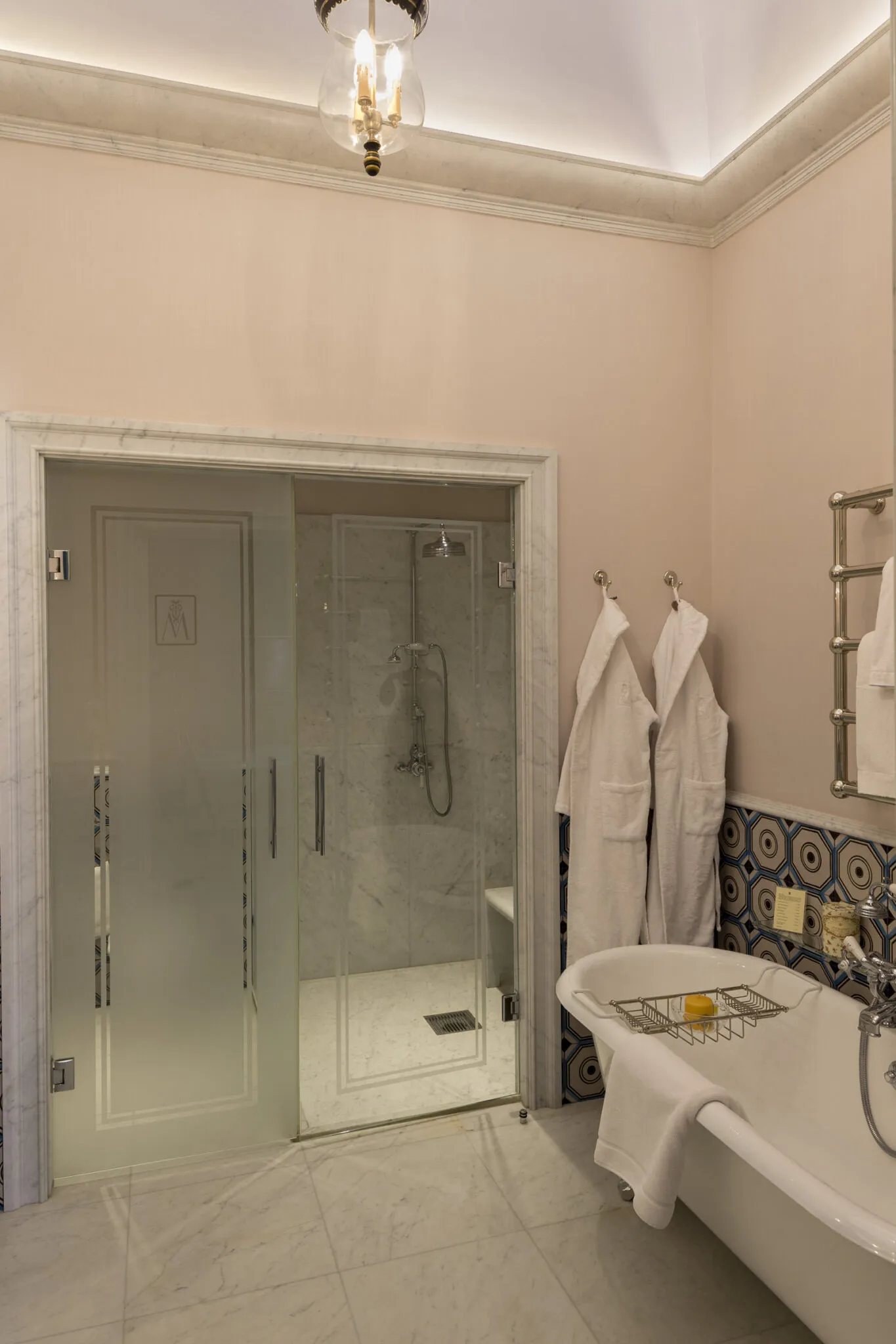 Bathroom with clawfoot tub and glass shower under a high ceiling