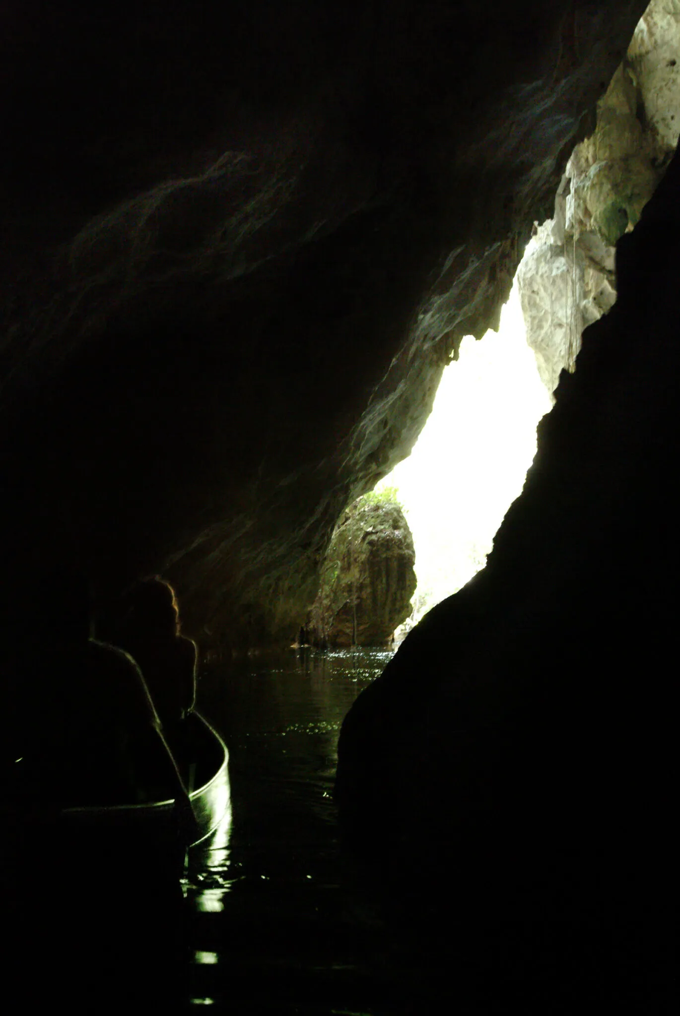 People in a canoe under a rock formation