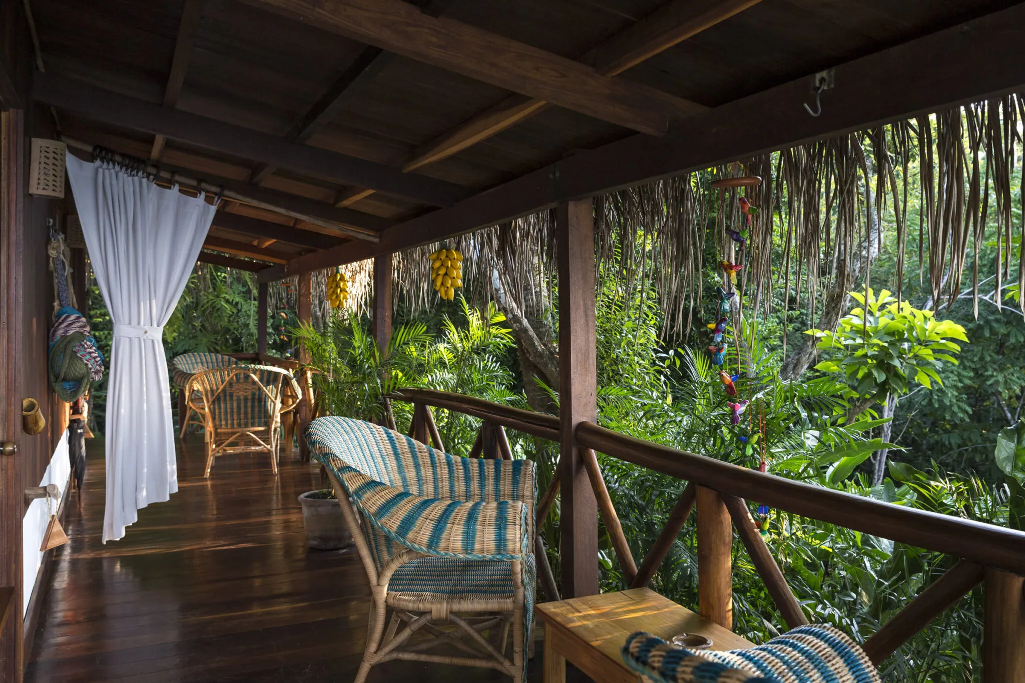 An outdoor deck, with two chairs overlooking a view of the rainforest.