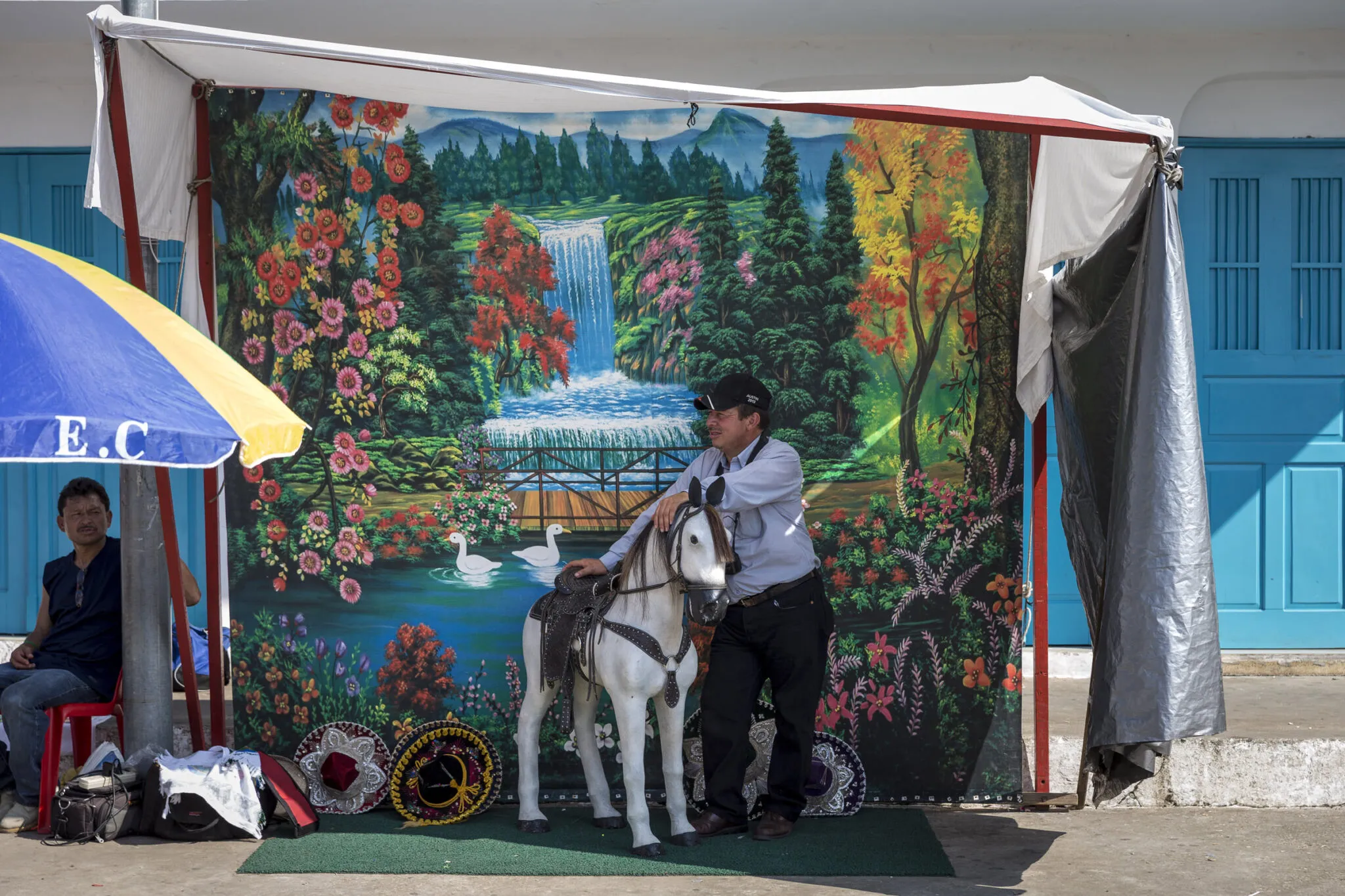 A man and donkey standing in front of a mural at the People interacting in a street festival at the Lake Petén Itzá and Flores tour.