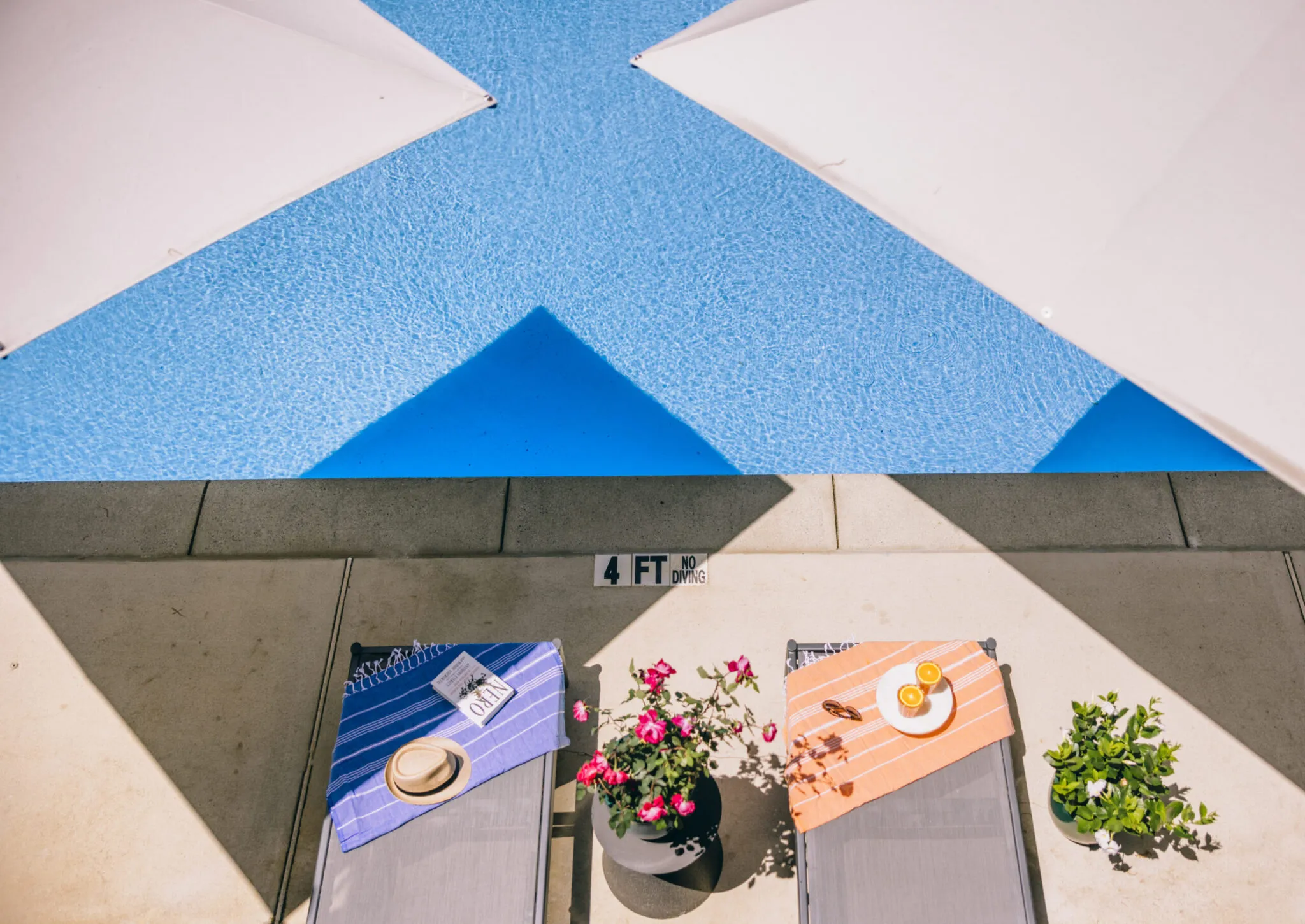 An aerial view of two lounge chairs next to a pool. next to