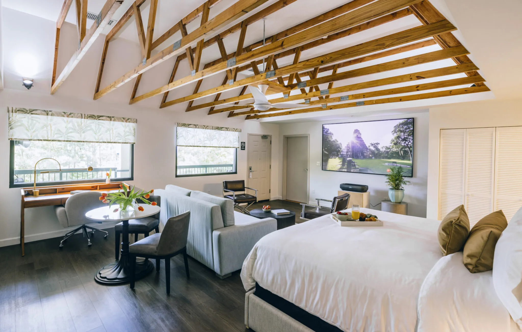 A view of the suite facing away from the bed, towards a set of large windows.